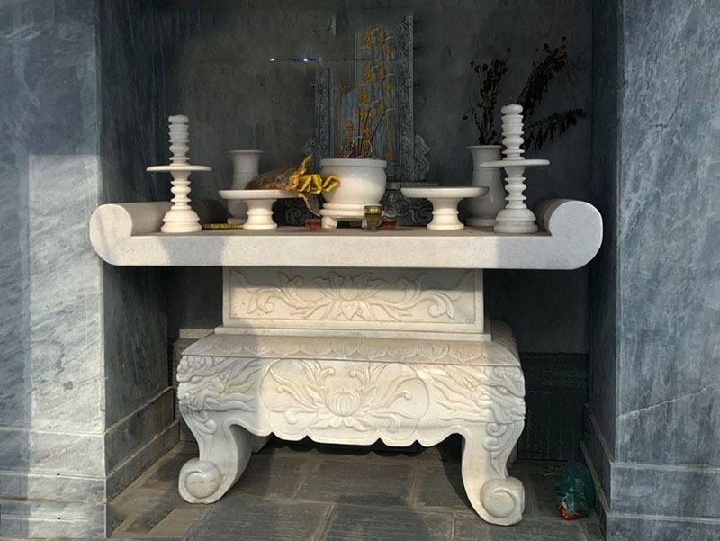 Phòng thờ hoặc khu vực tâm linh sử dụng bàn thờ, lư hương, hoặc vật phẩm bằng đá tạo cảm giác trang nghiêm và bền vững